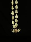 A 20th century Chinese necklace having a series of naturalistic light green jade beads with a silver