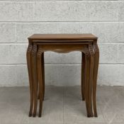 A 19th century French nest of walnut side tables each having a square top over a shaped apron raised