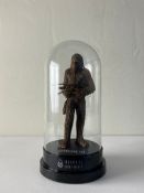 A large simulated bronze composite resin Chewbacca figure holding a Wookie Bowcaster weapon produced