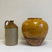 An early 20th century stoneware flagon along with a 19th century French terracotta pot in a crude