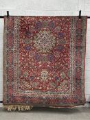 A 19th century Persian style Kashan carpet having a central medallion surrounded by scrolling