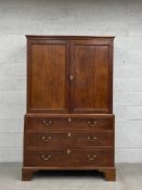 A Georgian mahogany press cupboard having a moulded cornice over two panelled cabinet doors