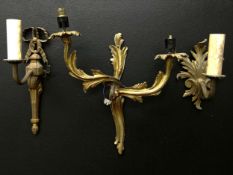 A collection of three 19th century and later gilt metal wall sconces to include one with a scrolling