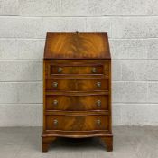 A 19th century Georgian style mahogany writing bureau having a book matched fall front tooled and