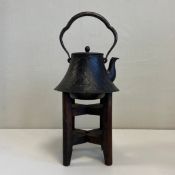 A 19th century Japanese cast iron Tetsubin or kettle having an arched and shaped swing handle over a