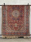 A 19th century Persian style Kashan carpet having a central medallion surrounded by scrolling