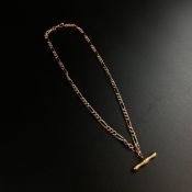 A 9ct gold Figaro chain with a T bar pendant. Weight: 7.38g