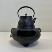A 19th century Japanese cast iron Tetsubin or kettle having an arched swing handle over a shaped