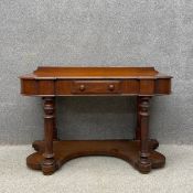 A Victorian mahogany duchess table or dresser having a shaped and moulded top with a shallow gallery