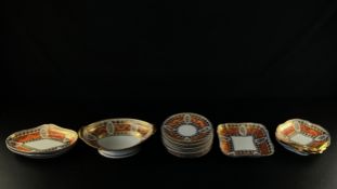 A 19th century porcelain part dinner service with bands of hand painted scrolling gilt foliate
