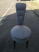 A contemporary early 20th century style salon chair having a narrow tapered button back over a round