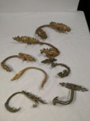 A miscellaneous collection of seven 19th century and later gilt metal and brass wall mounted drape