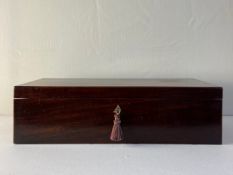 A 19th century mahogany writing slope having a rectangular top over two sunk handles with a small