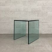 A contemporary thick plate glass side table of simple square form raised on side supports. H.60.5