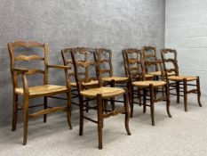 A set of eight 19th century French provincial oak ladder back dining chairs including two carvers