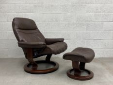 A vintage Scandinavian brown leather reclining armchair with a swivel action having a cushioned back