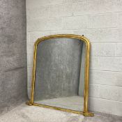 A large 19th century overmantel mirror having its original distressed plate in an arched and moulded