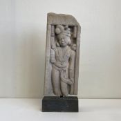 A large archaistic Indian sandstone figural carving depicting a noble or deity in traditional