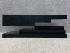 A contemporary Impossible Coffee Table having a powder coated black stainless steel top levitating