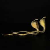 A pair of 20th century Indian school all-over engraved and cast brass figural Cobras. L.18cm