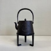 A 19th century Japanese cast iron Tetsubin or kettle on stand having an arched swing handle over a