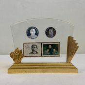 A 20th century Chinese award plaque having commemorative coins and stamps set into a sheet of