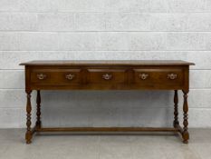 A 20th century Georgian style oak dresser having long rectangular thumb moulded plank top over three