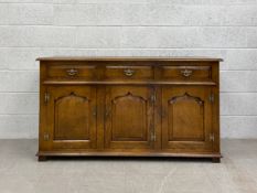 A Georgian style oak sideboard or dresser having a rectangular thumb moulded plank top over three