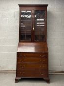 A late 19th century Georgian style mahogany bureau bookcase having a moulded cornice over two glazed