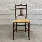 An Edwardian mahogany hall chair having a shaped top rail inlaid with a central oval medallion