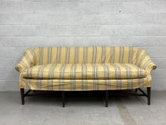 An early 19th century Georgian sofa or settee having a square drop down back with scrolled slanted