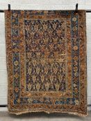 A 19th century Kazak rug having a repeating geometric flowerhead field over a midnight ground within