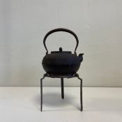 A 19th century Japanese cast iron Tetsubin or kettle on stand having an arched swing handle over a