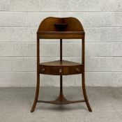 A late 18th century mahogany corner washstand having a bow fronted top shelf with a shaped gallery