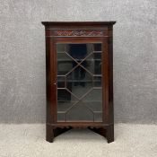 A 19th century mahogany floor standing corner display cabinet having a dentil moulded cornice over a