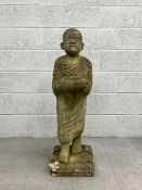 A vintage reconstituted stone stylised Buddhist monk garden statue raised on a square plinth base.
