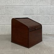 An early 20th century mahogany stationery box having a slanted tambour lid opening on to a