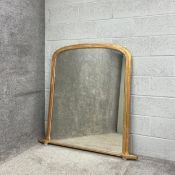 A large 19th century overmantel mirror having an arched plate in a moulded giltwood frame raised
