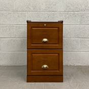 A contemporary mahogany filing cabinet having a square top with raised sides over two panelled