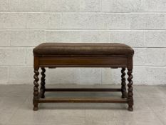 An early 20th century Jacobean style oak stool having a hinged brown velour upholstered stuffover