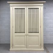 A contemporary painted wardrobe or linen cupboard having a moulded cornice above two long cabinet