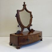 A 19th century mahogany toilet mirror having a shield shaped plate in a crossbanded frame with a cup