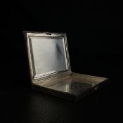 An early 20th century hallmarked .925 silver compact of rectangular form with a hinged engine turned