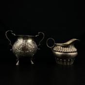 Two pieces of hallmarked silver to include a Rotherham & Sons creamer jug with a shaped spout over a