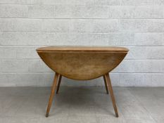 A mid century elm and beech Ercol Windsor Model 384 drop-flap dining table. H.71 W.124 D.113cm (