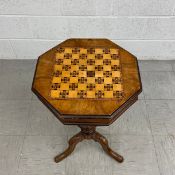 A 19th century walnut trumpet form work table with hinged chessboard inlaid top revealing fitted