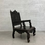 A 19th century Anglo-Indian teak armchair with all-over carved and pierced decoration. H.97cm