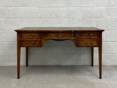 A Georgian style mahogany desk having a rectangular tooled and gilt green leather top with a