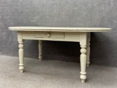 A C.1900 painted country pine dining table having a thick moulded oval plank top over a single