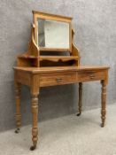 An Edwardian ash dressing table having a swing mirror with moulded cornice above a rectangular